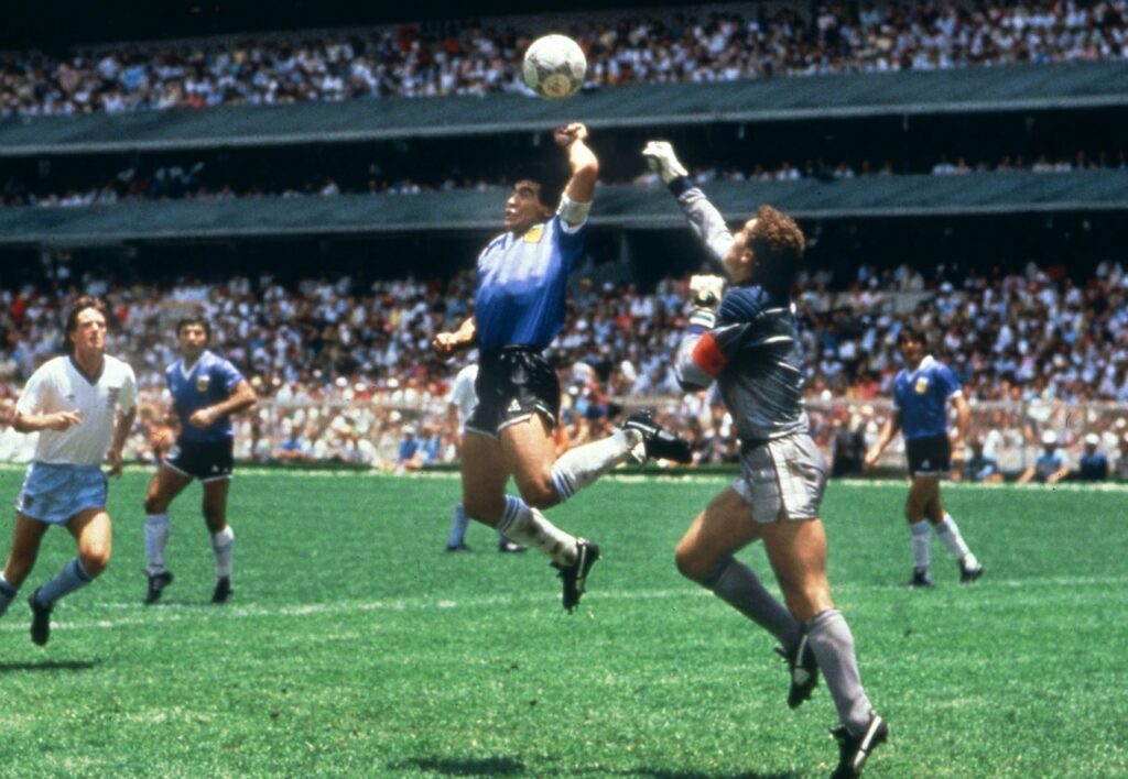La « Main de Dieu » fait référence à l'expression utilisée par Diego Maradona pour qualifier son but marqué volontairement avec la main, contre l'Angleterre (score final 2-1 pour l'Argentine) lors du quart de finale de la Coupe du monde 1986