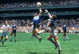 La « Main de Dieu » fait référence à l'expression utilisée par Diego Maradona pour qualifier son but marqué volontairement avec la main, contre l'Angleterre (score final 2-1 pour l'Argentine) lors du quart de finale de la Coupe du monde 1986